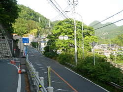 20号に合流手間から、中央の木の向こうが駅舎