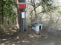 ポスト風の赤い物と地面に小さな小屋風な物